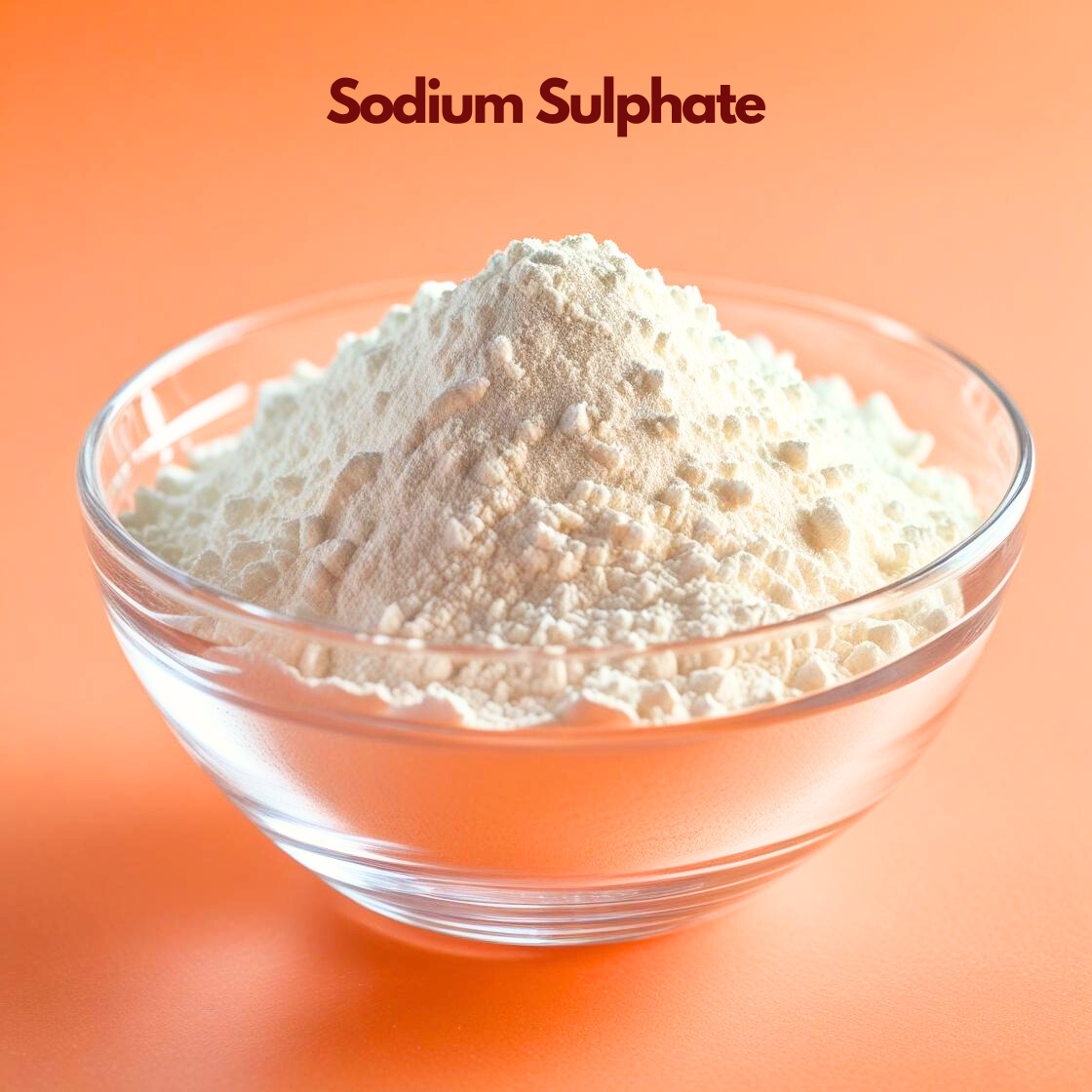 Glass bowl filled with a mound of fine white sodium sulphate powder labeled "Sodium Sulphate" placed on a bright orange background. Sodium sulphate is commonly used in cosmetic and personal care formulations as a filler processing aid and cleansing ingredient.