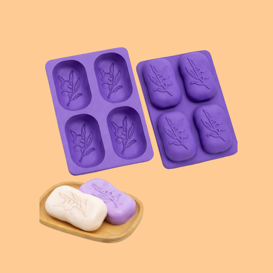Two purple silicone soap molds with embossed floral oval cavities displayed with finished decorative soap bars on wooden tray, silicone mold used for handmade soap production, cosmetic soap crafting and artisan bath products.