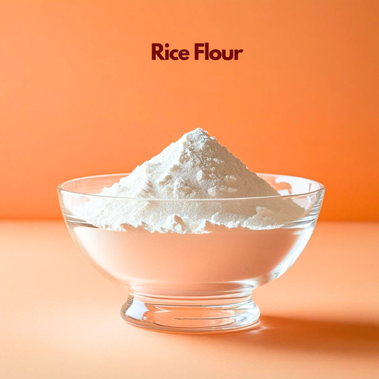 Clear glass bowl containing a mound of fine white rice flour labeled "Rice Flour" placed on a bright orange background. Rice flour is a natural cosmetic ingredient commonly used in face masks scrubs and skincare formulations for gentle exfoliation oil absorption and skin smoothing.
