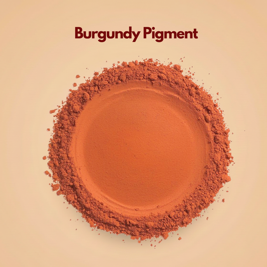 Circular layer of burgundy pigment powder featuring a warm reddish brown tone with a smooth pressed center and crumbly textured edges. Fine powder particles surround the outer edge, showing its soft mineral consistency. This burgundy pigment powder is suitable for cosmetic formulations including lip products and pressed powders.