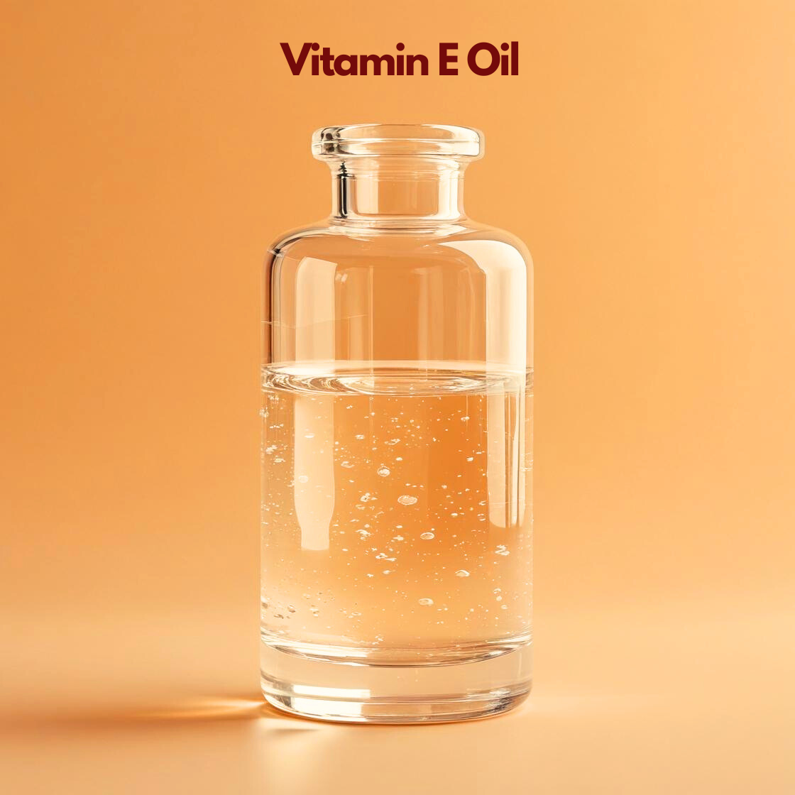 Clear glass bottle containing transparent oil labeled "Vitamin E Oil" displayed on a warm orange background with visible bubbles in the liquid. Vitamin E oil is a cosmetic antioxidant used in skincare formulations to protect oils improve product stability and nourish skin.