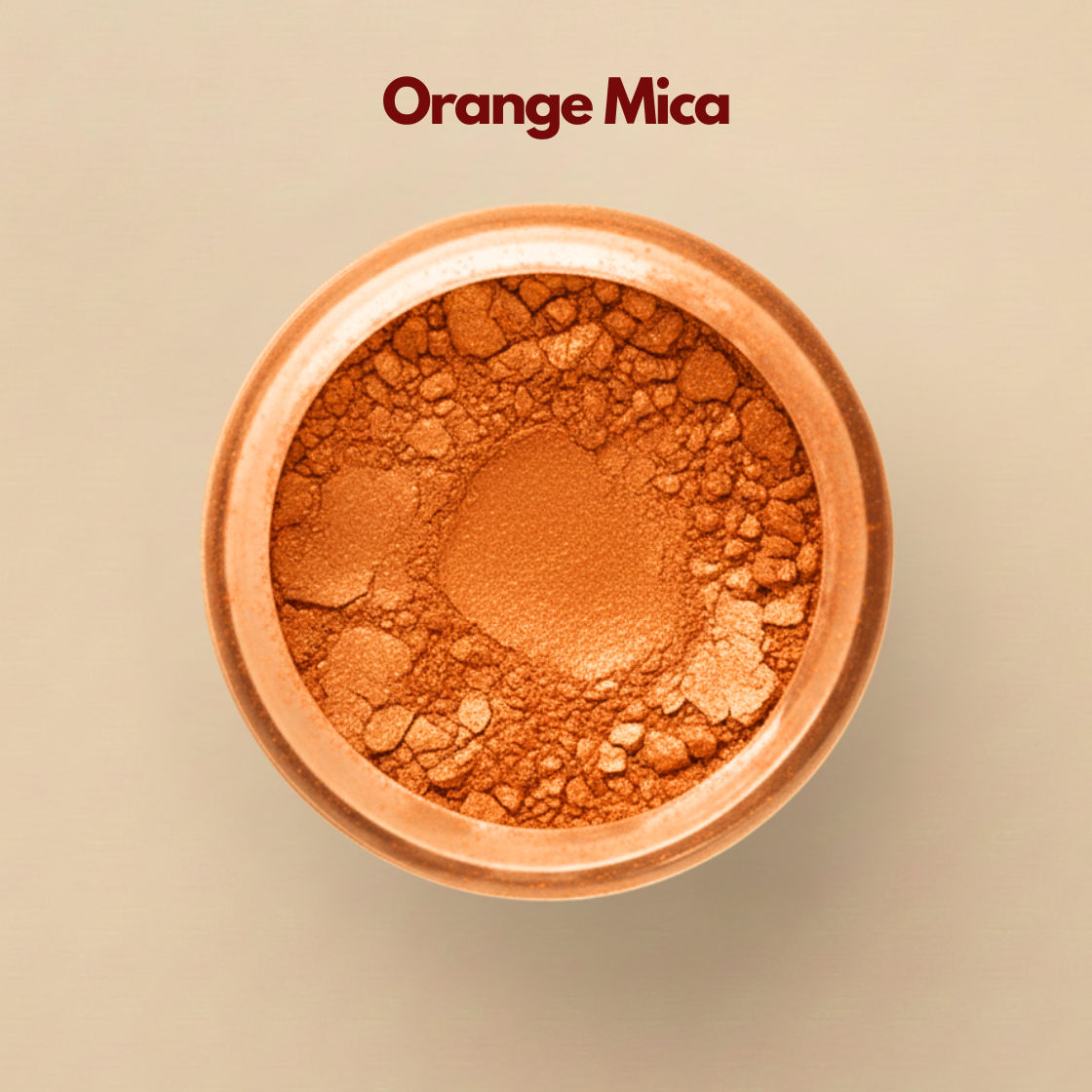 Close up top view of orange mica powder in a round container, displaying a vibrant metallic orange tone with fine reflective particles. The surface appears textured with small pressed and loose shimmer fragments. This orange mica powder for cosmetics is used to create luminous effects in eye shadow and highlighter.