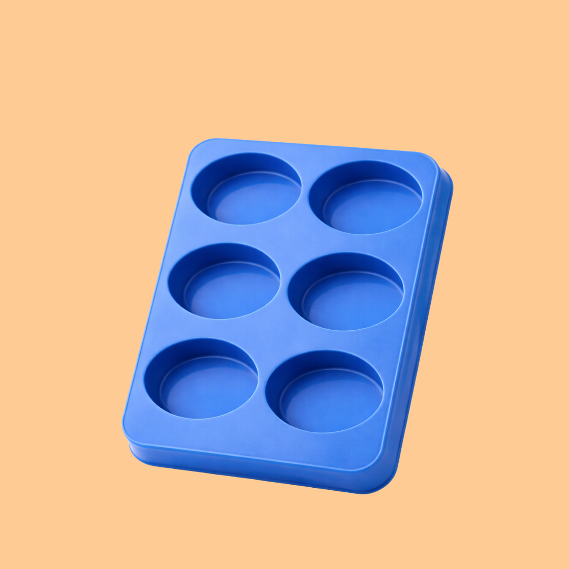 Blue silicone soap mould tray with six round cavities placed on a beige background, flexible reusable mold used for handmade soap bars, DIY soap making, melt and pour soap crafting, and cosmetic product manufacturing.