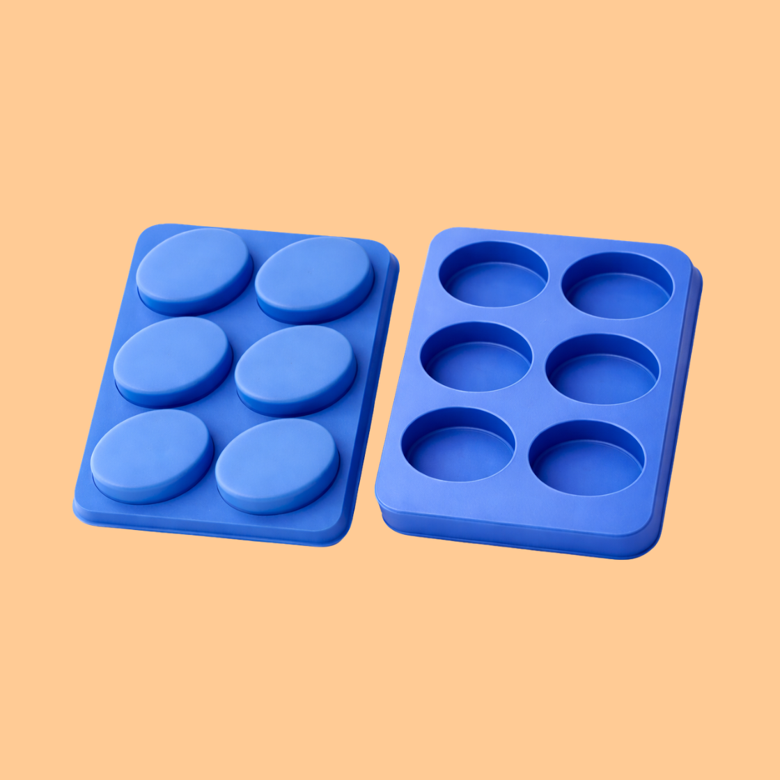 Blue silicone round cavity soap mould tray displayed with four finished pastel colored round soap bars in front, flexible silicone mold used for handmade soap production, artisan soap crafting, and cosmetic bath product making.