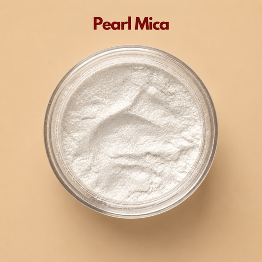 Top view of pearl mica powder inside a round container, featuring a soft white shimmer with a smooth and luminous mineral texture. The surface shows subtle natural creases and a gentle reflective glow. This pearl mica powder for cosmetics is used to add brightness and a radiant finish to makeup and skincare formulations.