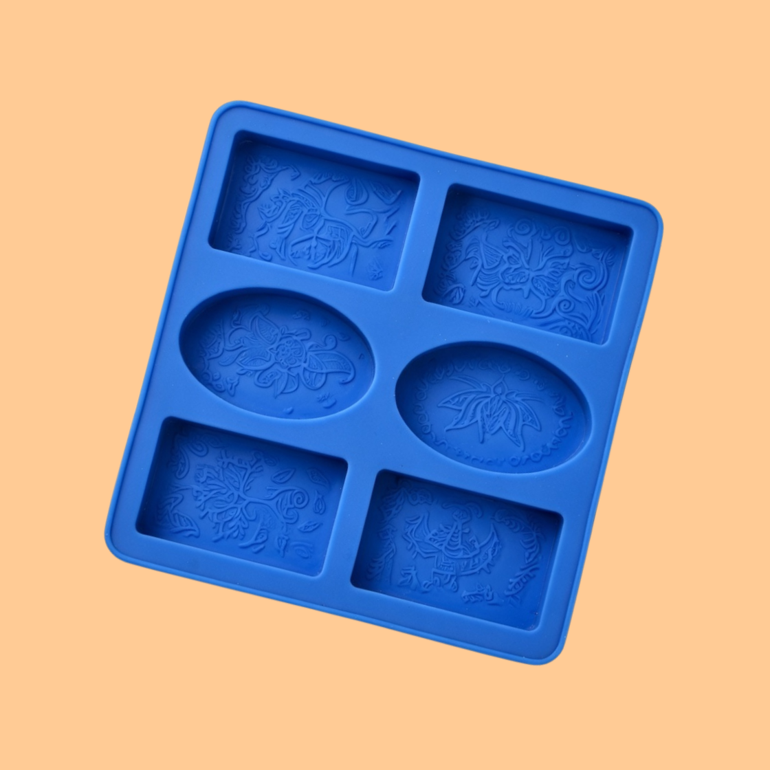  Blue silicone decorative soap mould tray with six cavities featuring embossed floral and ornamental patterns in oval and square shapes, mold used for decorative handmade soap bars, artisan soap production, and bath product crafting.