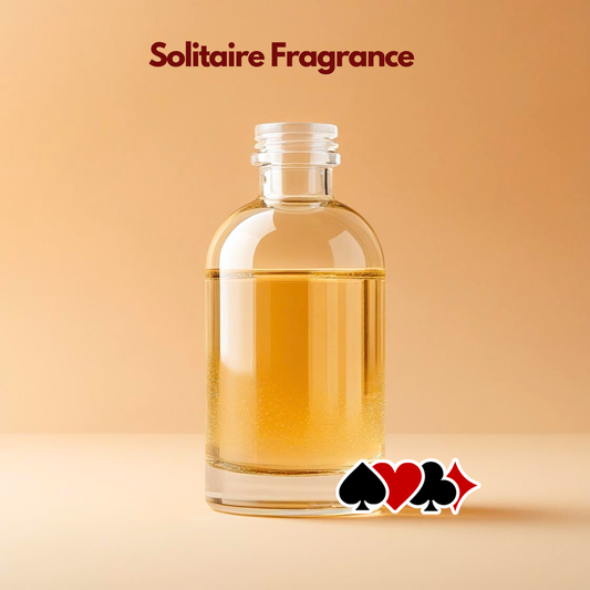 Glass bottle containing amber liquid labeled Solitaire Fragrance with playing card suit symbols illustrated at the base. This oil soluble fragrance for cosmetics suggests a bold distinctive aroma suited for premium cosmetic formulations.