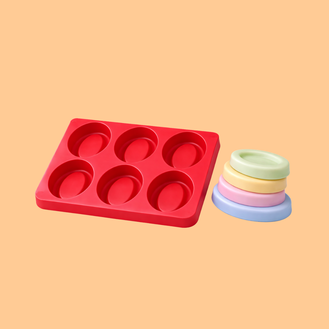 Red silicone oval soap mould tray displayed with stacked pastel colored oval soap bars, reusable silicone mold used for handmade soap crafting, bath product making, and cosmetic soap manufacturing