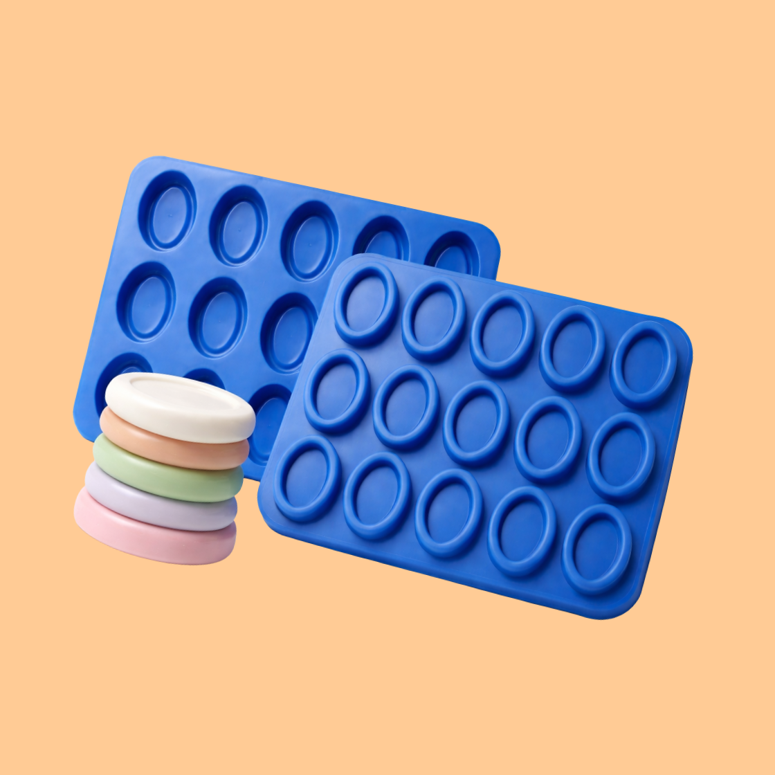 Blue silicone mini soap mould trays displayed with stack of small pastel colored oval soaps, flexible mold used for DIY soap crafting, handmade guest soaps, and artisan bath product manufacturing.