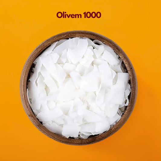 Wooden bowl filled with white wax flakes labeled "Olivem 1000" placed on a bright orange background. Olivem 1000 is a natural olive derived cosmetic emulsifier used in skincare formulations to create stable creams lotions and moisturizing emulsions.