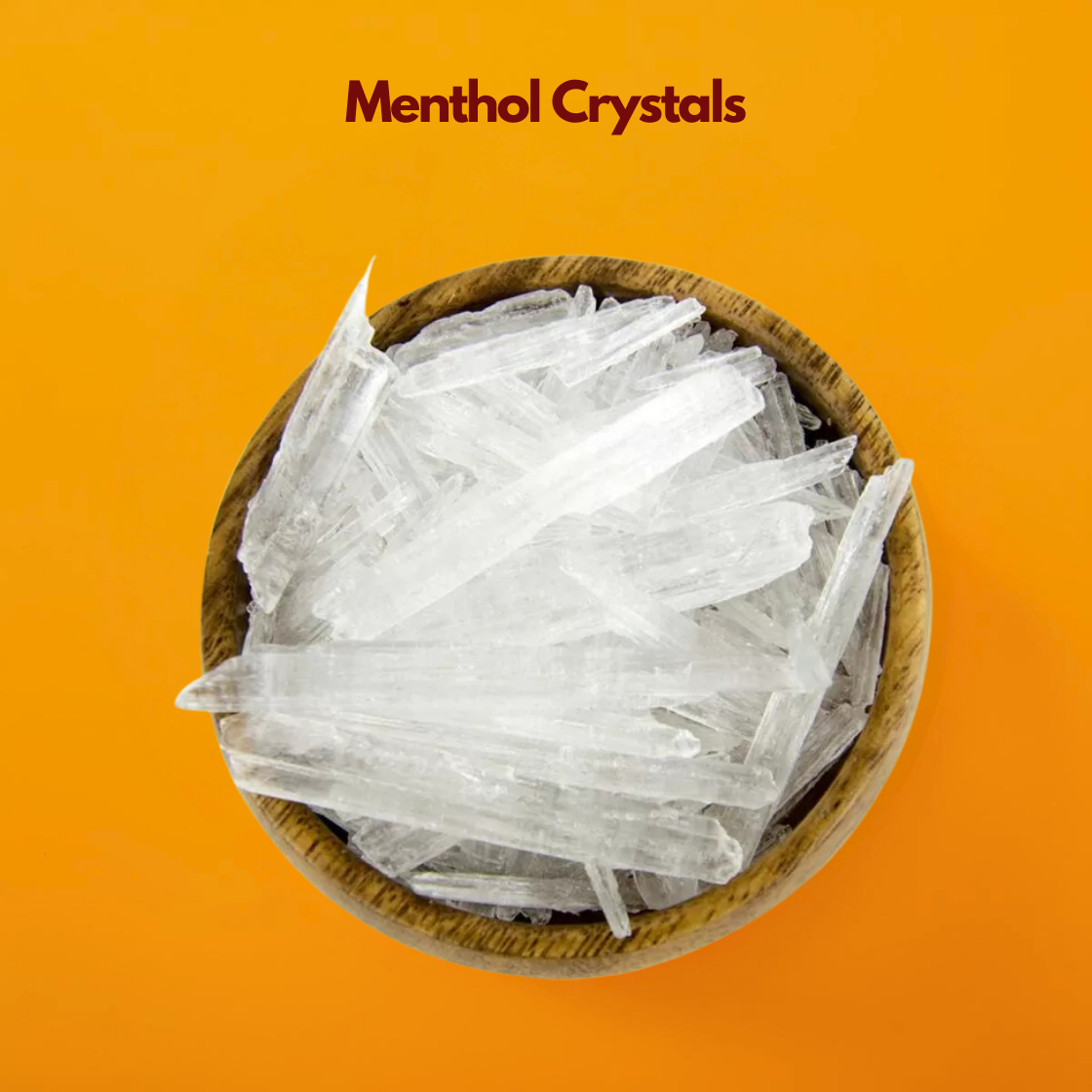  Wooden bowl filled with long translucent menthol crystals labeled Menthol Crystals placed on a vibrant orange background. Cosmetic grade menthol crystals are widely used in skincare haircare and personal care formulations to provide a cooling refreshing sensation.