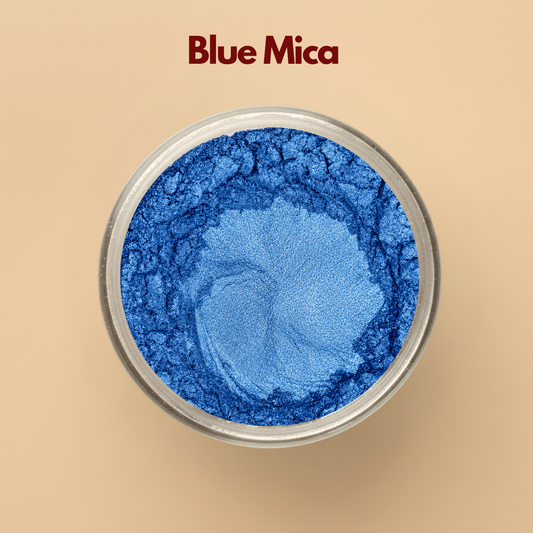 Blue mica powder with rich metallic shimmer displayed in a round transparent cosmetic jar on a beige background. Cosmetic grade blue mica pigment used in soap making, lip gloss, makeup, bath products, skincare formulations, candles, and DIY cosmetic applications. The image highlights vibrant blue shimmer pigment and smooth fine mica powder texture.