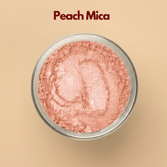Peach mica pigment powder in a transparent cosmetic container with soft peach shimmer finish on a beige background. Cosmetic grade mica powder designed for lip gloss, soap making, skincare, makeup formulations, body shimmer products, and DIY cosmetic creations. The image showcases elegant peach shimmer and finely milled cosmetic pigment texture.