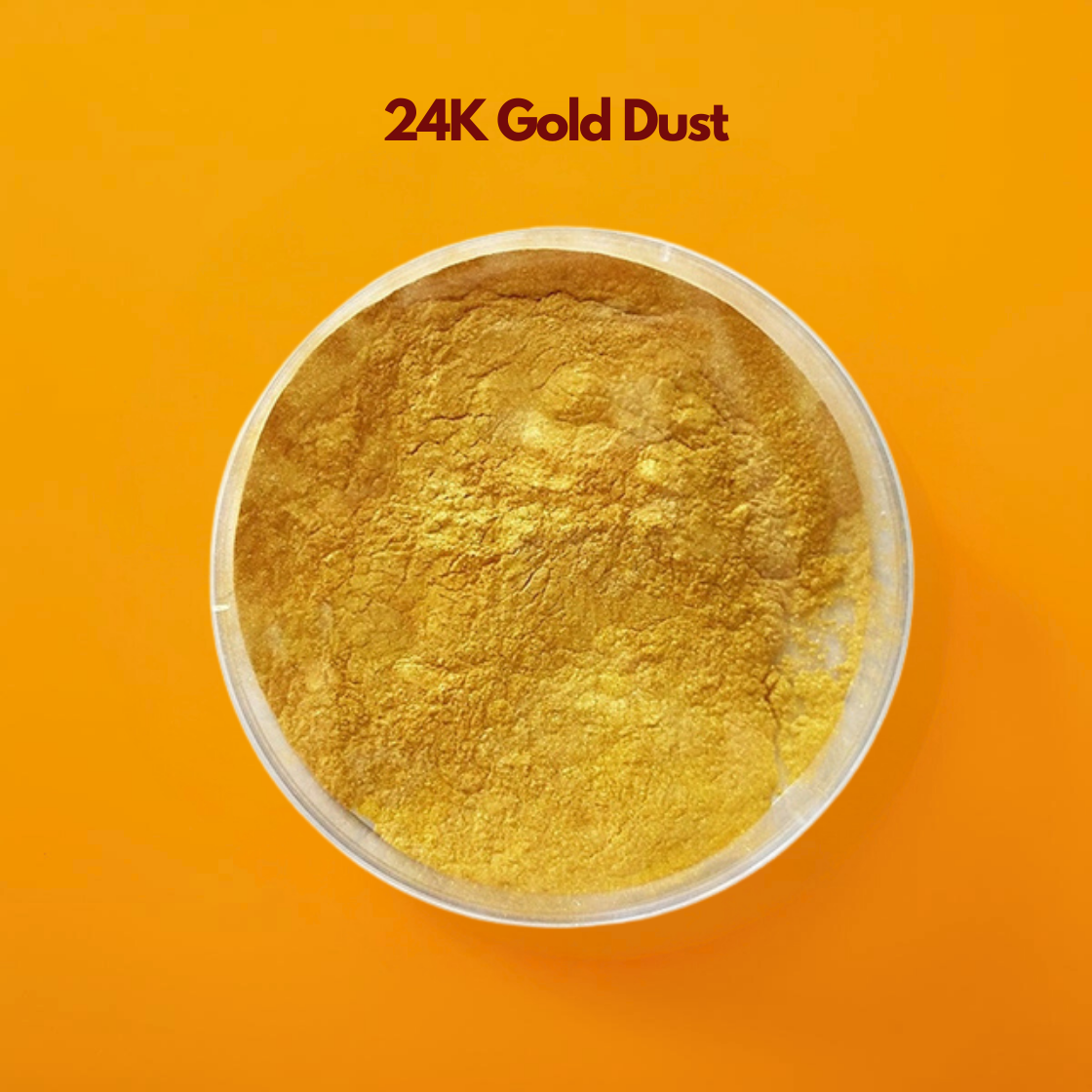 A small, clear glass bowl filled with a pile of shimmering "24K Gold Dust". The powder has a brilliant metallic yellow gold luster and a fine, lightweight texture. It is centered against a vibrant, solid orange background. The text "24K Gold Dust" is centered at the top in dark maroon.