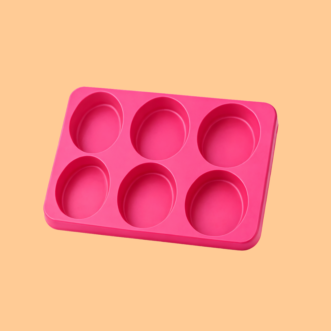Pink silicone soap mould tray with six oval cavities displayed on neutral background, flexible silicone mold used for handmade soap bars, melt and pour soap making, and artisan cosmetic soap production.
