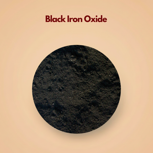 Top view of black iron oxide pigment powder forming a dark matte mineral surface with a slightly rough and natural texture. The deep charcoal black tone appears highly concentrated and finely milled. This black iron oxide pigment powder is used in eyeliners, mascaras and mineral makeup formulations.