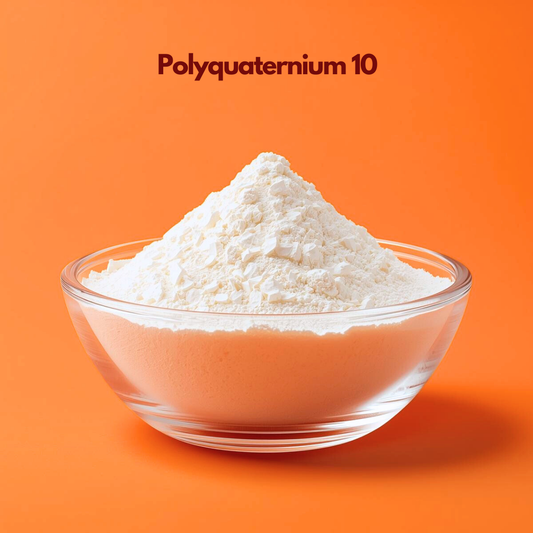 Transparent bowl filled with fine white polyquaternium 10 powder labeled Polyquaternium 10 placed on a bright orange background. Polyquaternium 10 is a conditioning polymer used in shampoo and haircare formulations to improve softness smoothness and manageability.