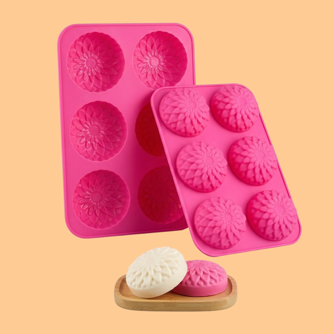 Two pink silicone flower soap molds with round floral cavities displayed with finished handmade soap bars on a wooden soap dish, decorative silicone mold used for handmade soaps, DIY bath products and artisan soap making.