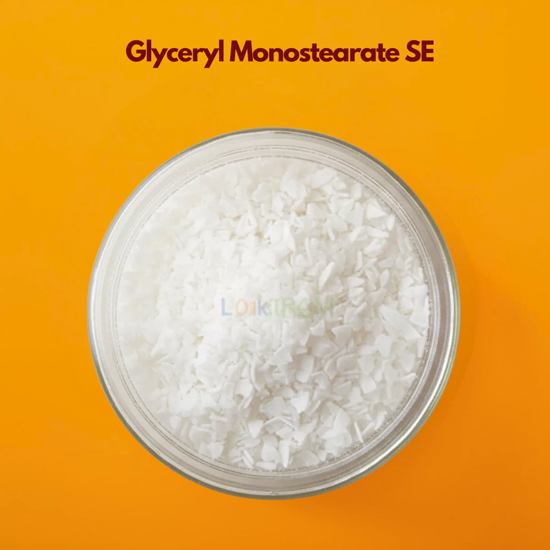 A circular close-up image showing a dense collection of Glyceryl Monostearate SE wax flakes. The flakes are thin, irregular and opaque white, resembling small shards of coconut. They are positioned against a vibrant orange background with the product name centered at the top.