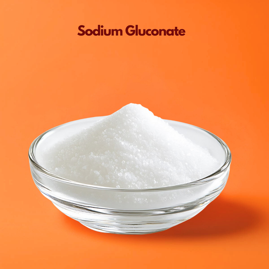 Transparent bowl containing fine white sodium gluconate powder labeled "Sodium Gluconate" displayed on an orange background. Sodium gluconate is a cosmetic chelating agent used in skincare formulations to improve stability and enhance preservative performance.