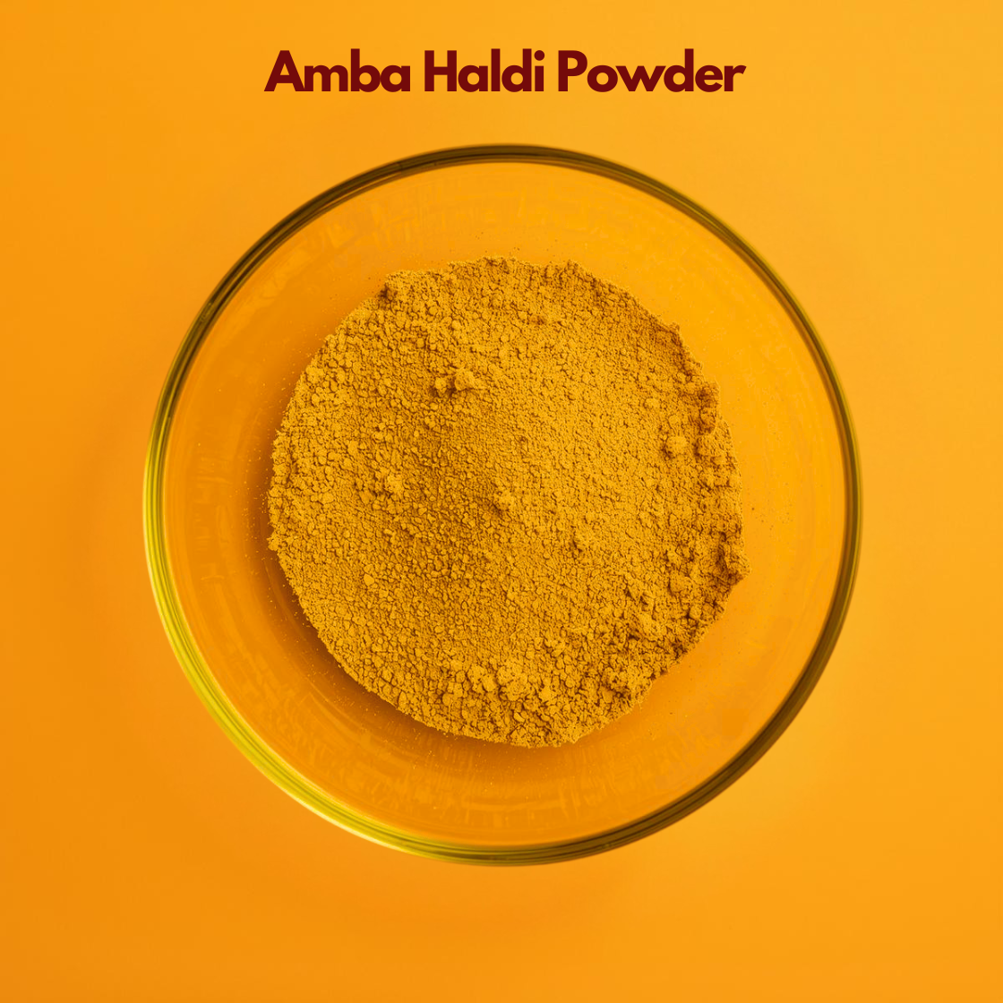 Top view of Amba Haldi Powder in a transparent bowl, featuring fine mustard yellow herbal powder with soft texture against an orange backdrop. ginger botanical powder commonly used in natural skincare masks, herbal beauty formulations and Ayurvedic cosmetic applications.