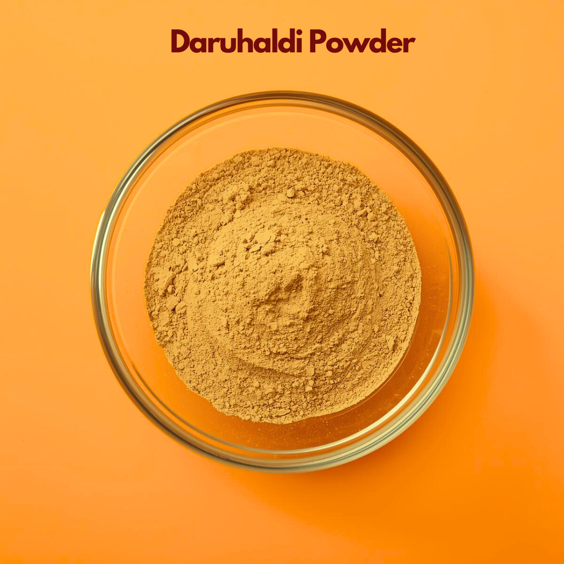 Overhead shot of Daruhaldi Powder in a clear glass bowl on a bright orange surface, featuring finely milled yellow brownish herbal powder with soft consistency. Ayurvedic botanical powder used in natural skincare masks, soothing treatments and herbal cosmetic formulations.