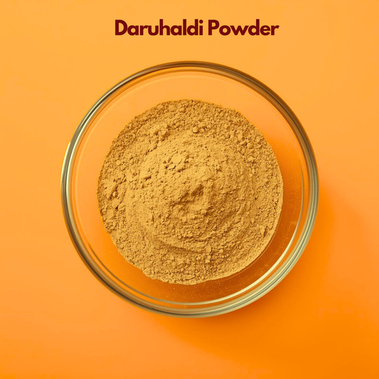 Overhead shot of Daruhaldi Powder in a clear glass bowl on a bright orange surface, featuring finely milled yellow brownish herbal powder with soft consistency. Ayurvedic botanical powder used in natural skincare masks, soothing treatments and herbal cosmetic formulations.