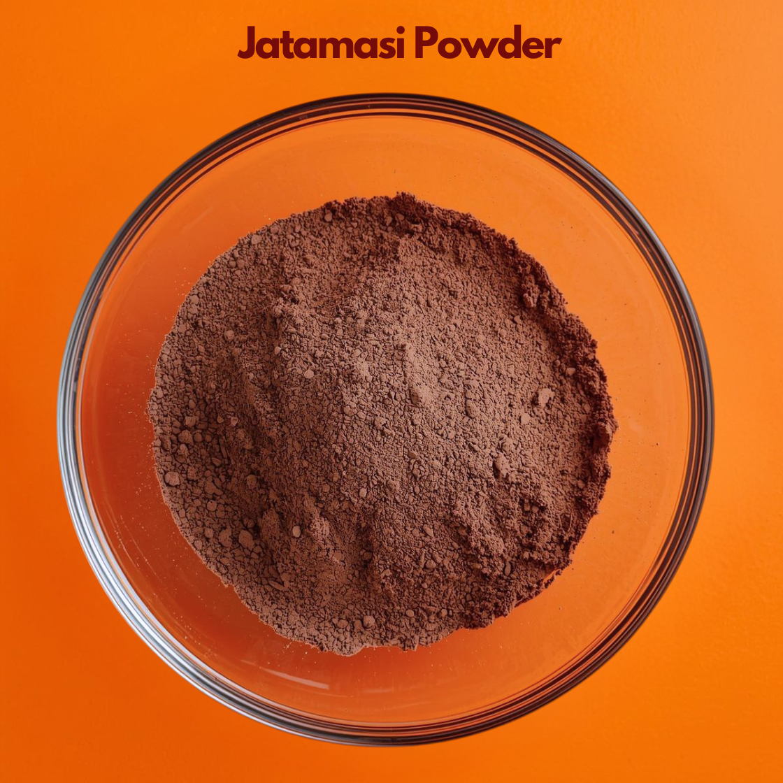 Overhead close up of Jatamasi Powder in a transparent bowl, featuring dark brown finely ground herbal powder against a vibrant orange surface. Ayurvedic botanical ingredient commonly used in natural hair care and traditional herbal preparations.