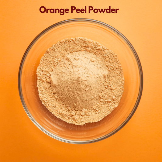 Top view of Orange Peel Powder in a round glass bowl, showing fine citrus toned beige powder evenly spread against a bright orange background. Natural herbal powder used in skincare for exfoliating face packs, brightening treatments and cosmetic formulations.