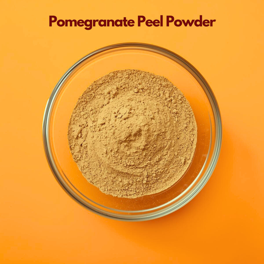 Overhead shot of Pomegranate Peel Powder in a transparent bowl, displaying finely milled light brown powder with smooth consistency on an orange background. Botanical herbal powder used in natural skincare masks and antioxidant rich cosmetic applications.