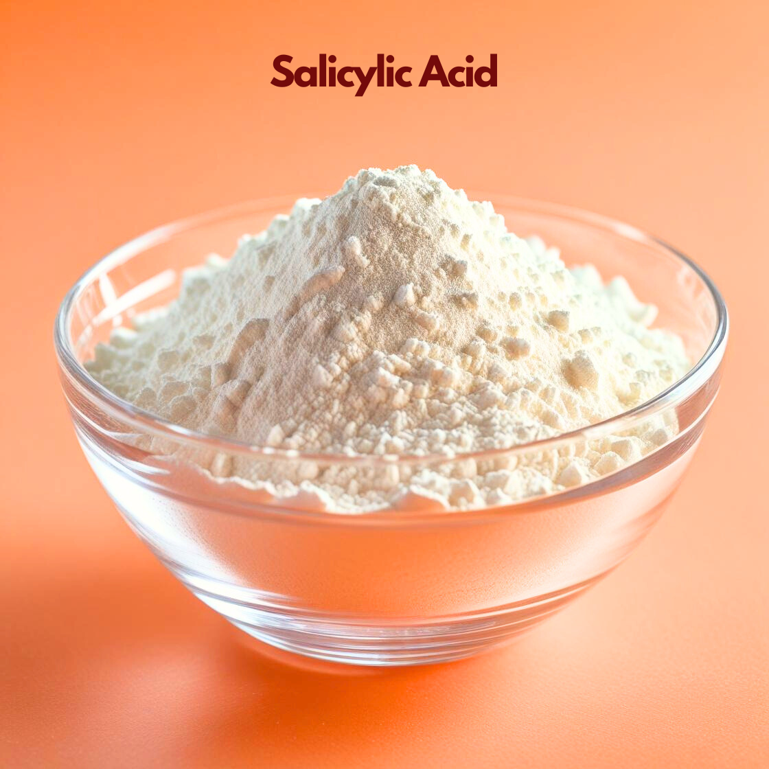 A mound of fine, snow white Salicylic Acid powder with a soft, matte texture, presented in a clear glass bowl. The bowl is centered against a vibrant, solid orange background. The product name "Salicylic Acid" is displayed at the top in dark maroon text.